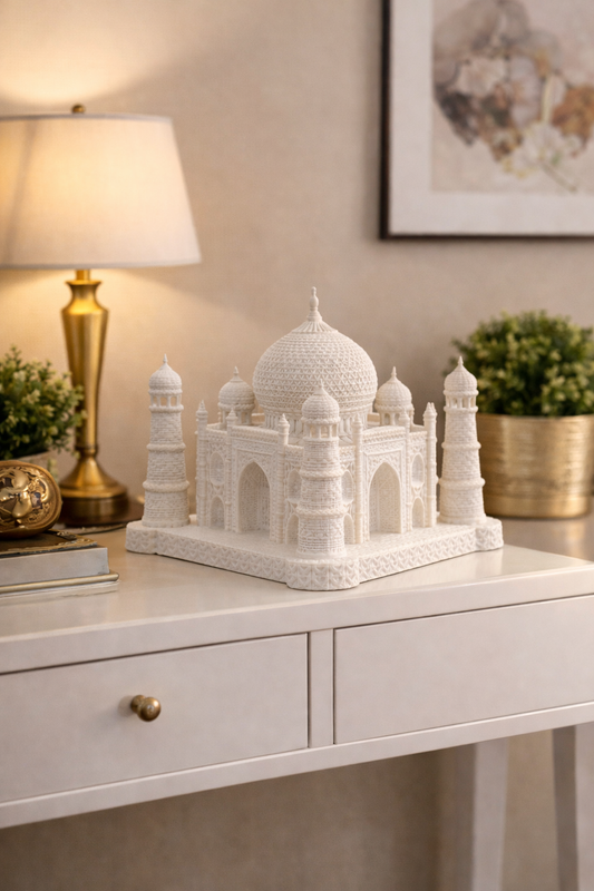 White Taj Mahal model on a desk with a lamp and decor items in the background