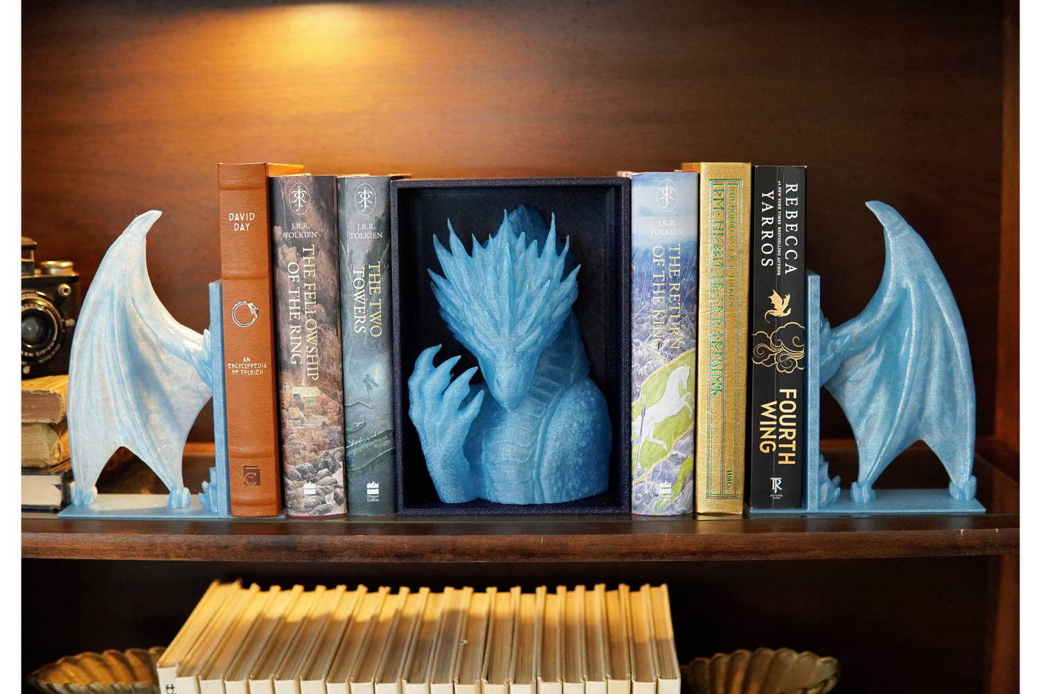 Bookends shaped like dragons on a bookshelf with books.