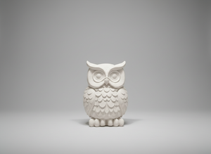 Decorative owl sculpture on a glass table in a stylish interior setting with shelves and lights.