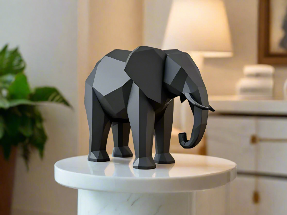 Black low poly geometric elephant sculpture on white pedestal - modern minimalist home decor for Indian homes
