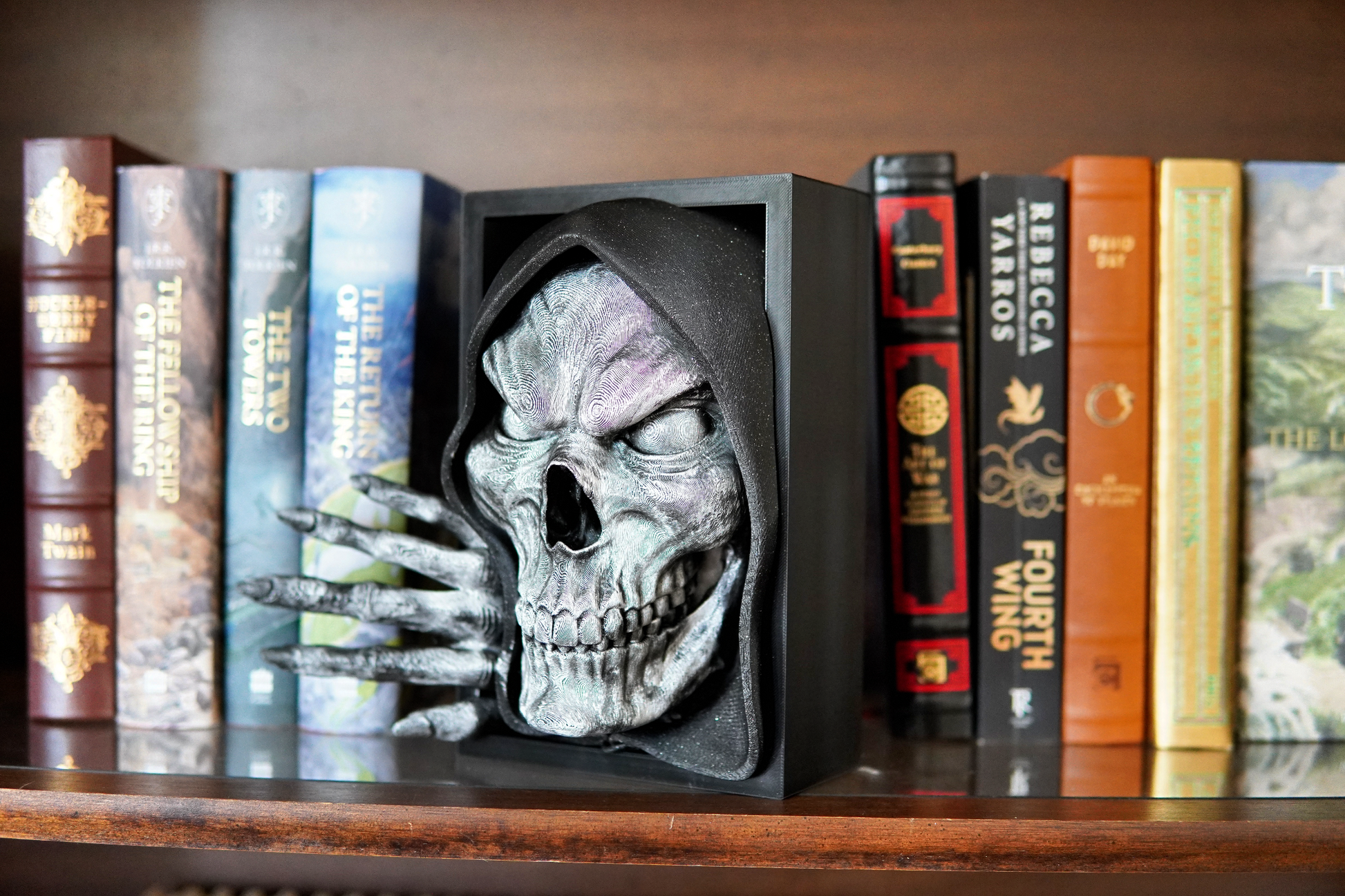 Skull-shaped bookend on a shelf with books